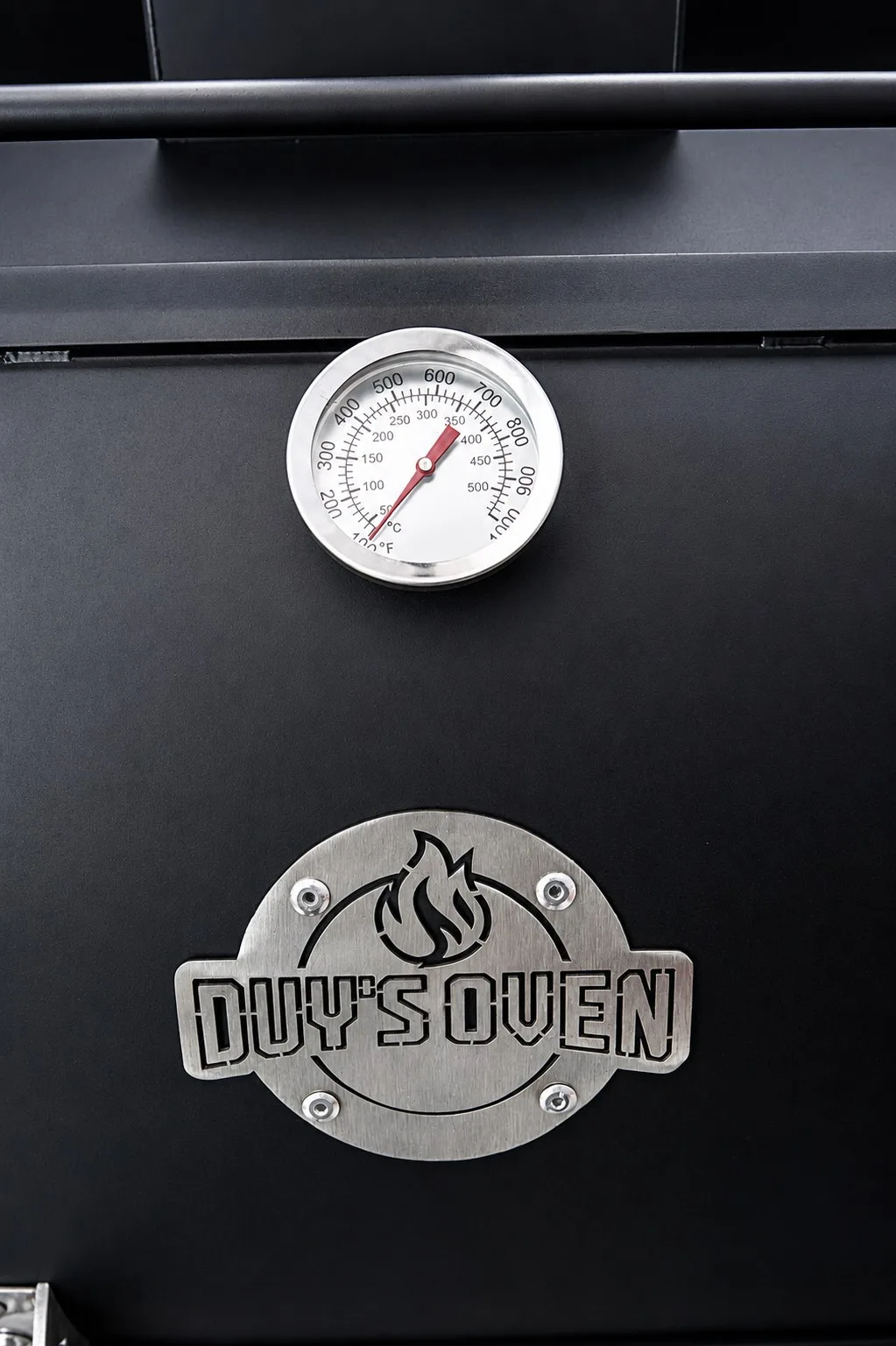 Đồng hồ nhiệt trên nắp lò và huy hiệu Duy's Oven